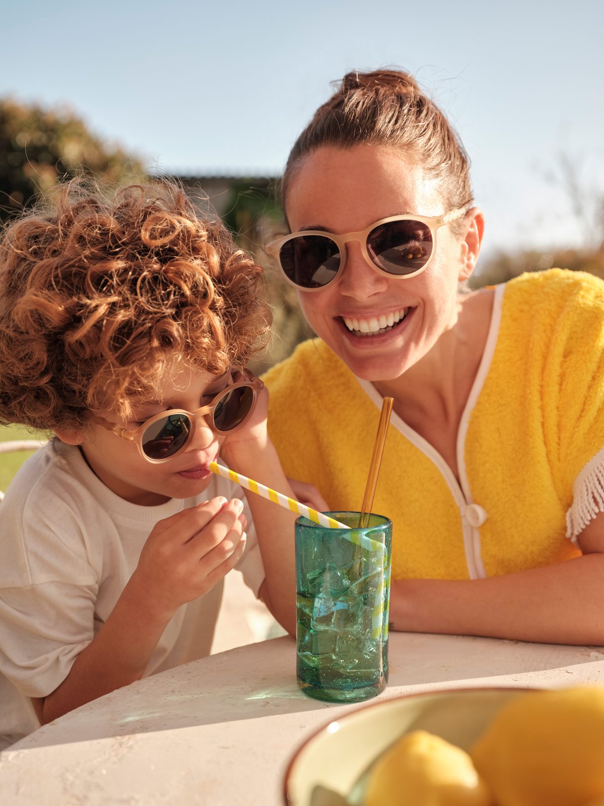 Parent and child wearing Olivio sunglasses outdoors in summer light