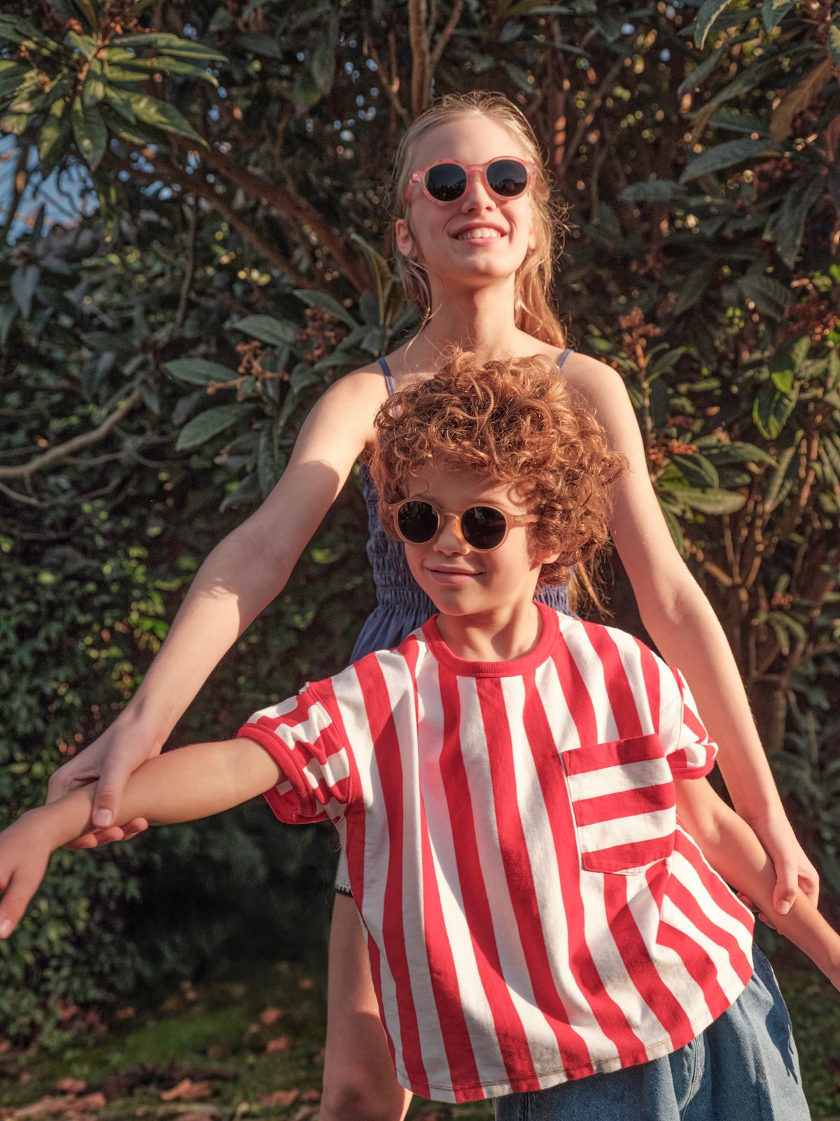 Two children of different ages wearing Olivio sunglasses side by side